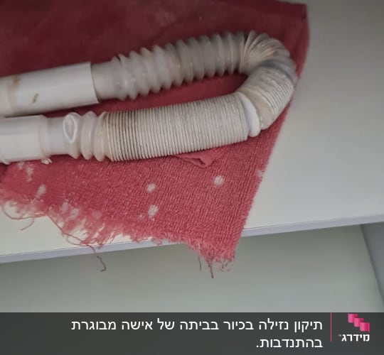תיקון נזילה בכיור בביתה של אישה מבוגרת בהתנדבות. 